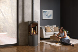 Cozy up next to the Onyx Liv 3 gas stove with dark wood floors and dark grey walls.